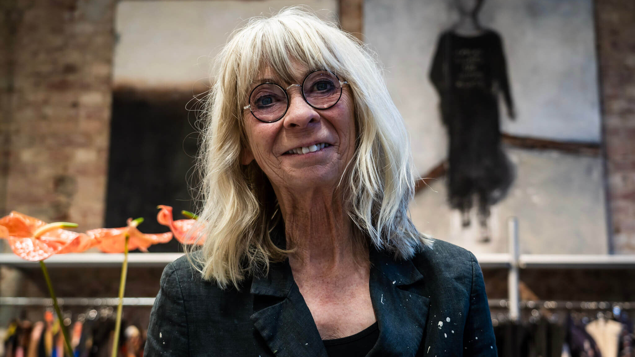 Susy Grundahl foran et par af de udstillede malerier hos Marie Lahn. Foto: Fjodor Pedersen.