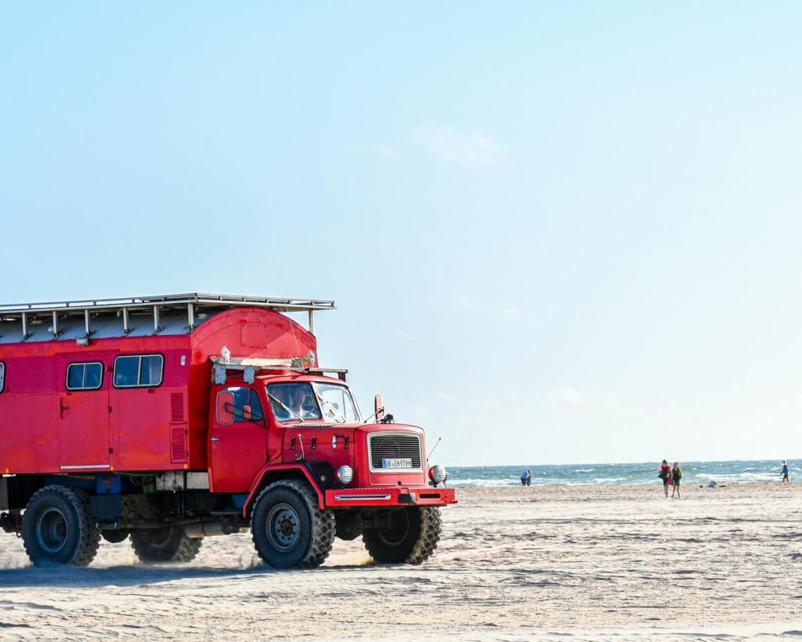 a red truck on a beach