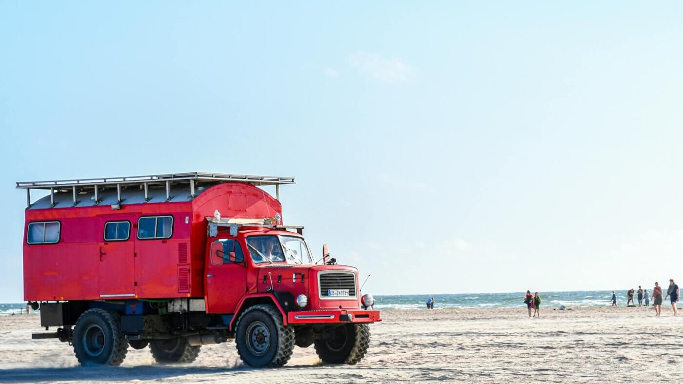 a red truck on a beach