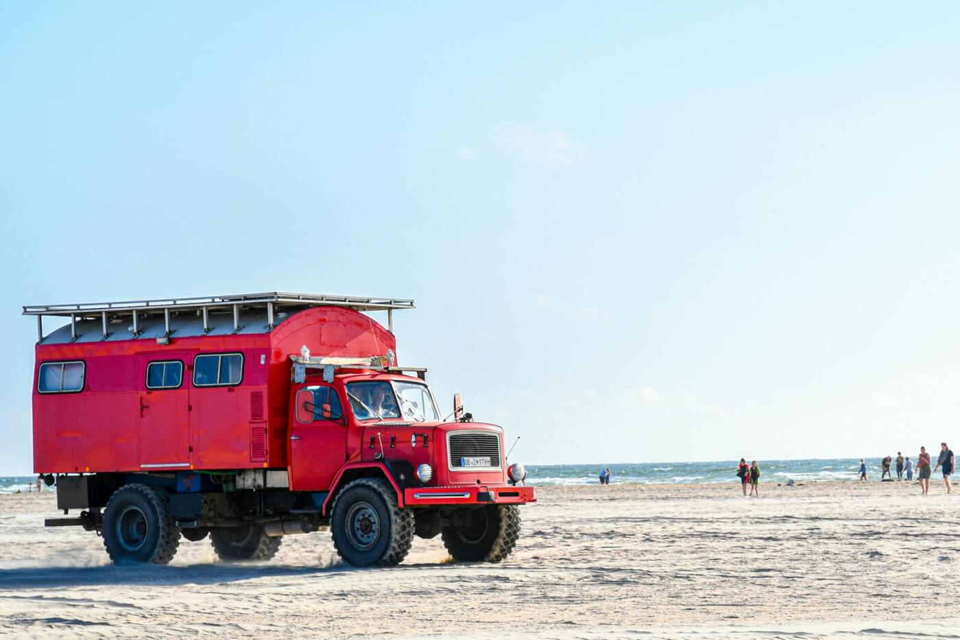 a red truck on a beach