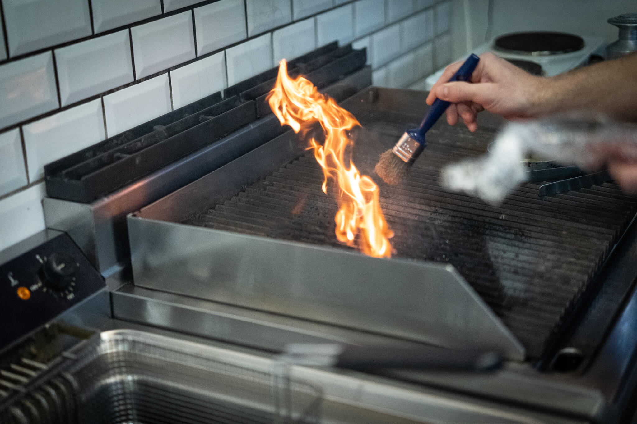 Når der pensles med olie på grillen opstår der flammer i det lille køkken i den ombyggede container. Foto: Fjodor Pedersen.