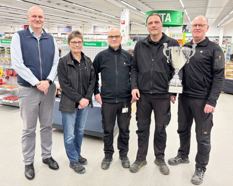 Personalet hos Lemwigh-Müller i Esbjerg med pokalen som det synlige bevis på den fine titel. Pressefoto.