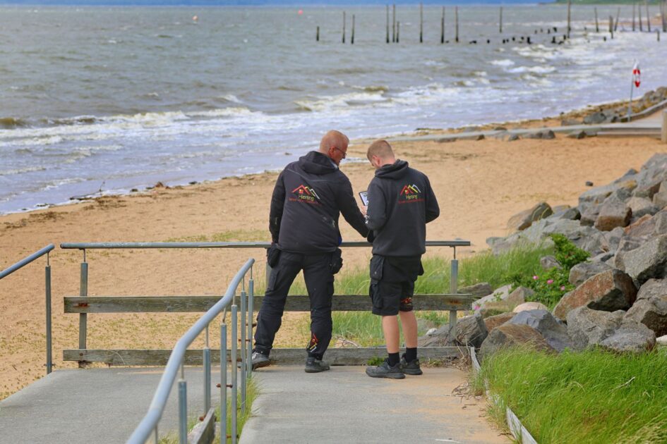 Håndværkere fra Hjerting Tømrer- og Snedkerforretning tager mål til det kommende rækværk ved strandnedgangen. Foto: Johnny Tauman.
