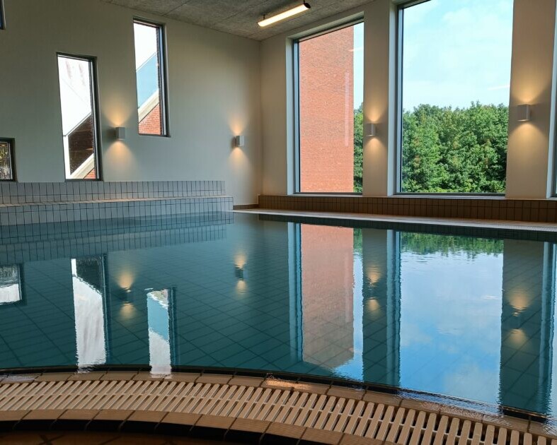 Det store varmtvandsbassin i Ribe Svømmebads nye wellnessafsnit kan nydes med udsigt til grønne omgivelser. Foto: Privat.