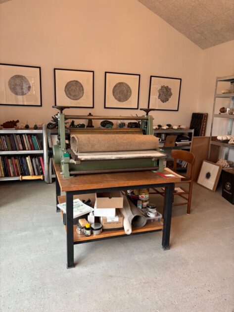 Trykpresse og arbejdsbord i det lyse atelier, hvor gæster kan få et indblik i den kunstneriske proces. Foto: Privat.