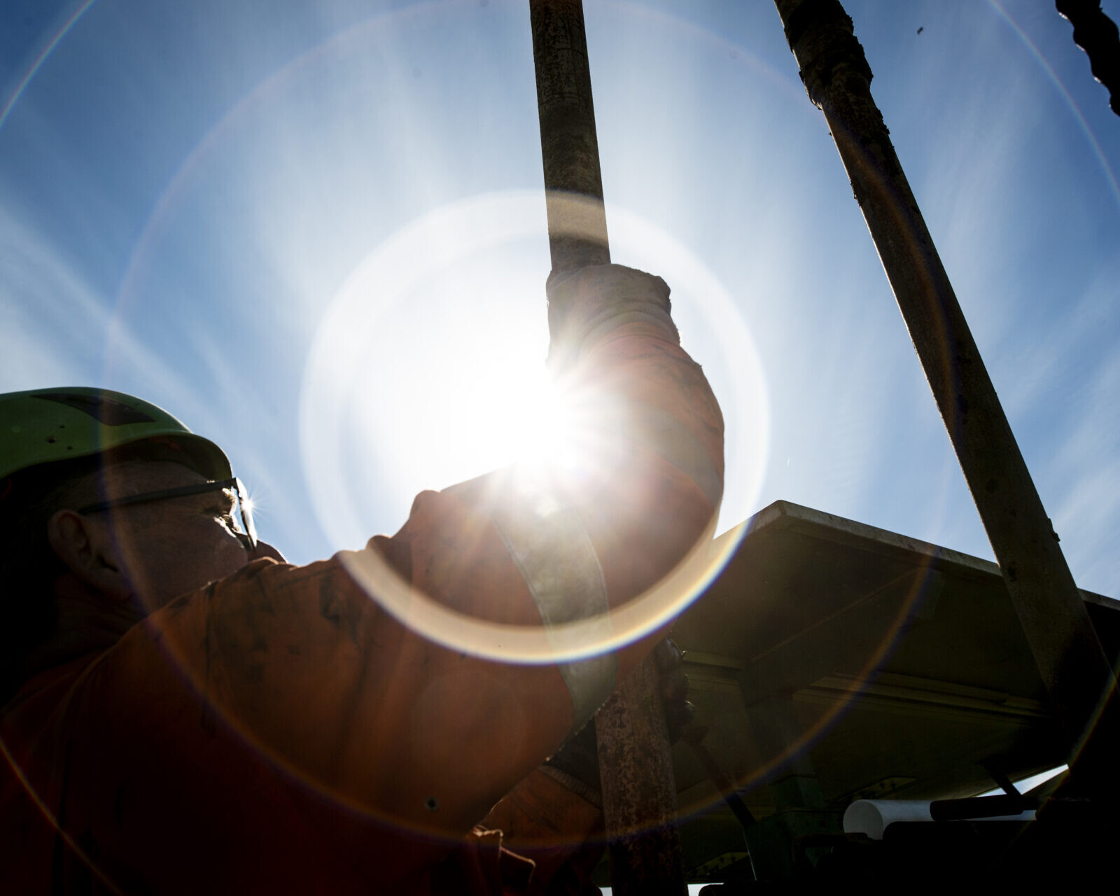 En borearbejder fra Jysk Geoteknik i aktion – med solen som bagtæppe. Pressefoto.