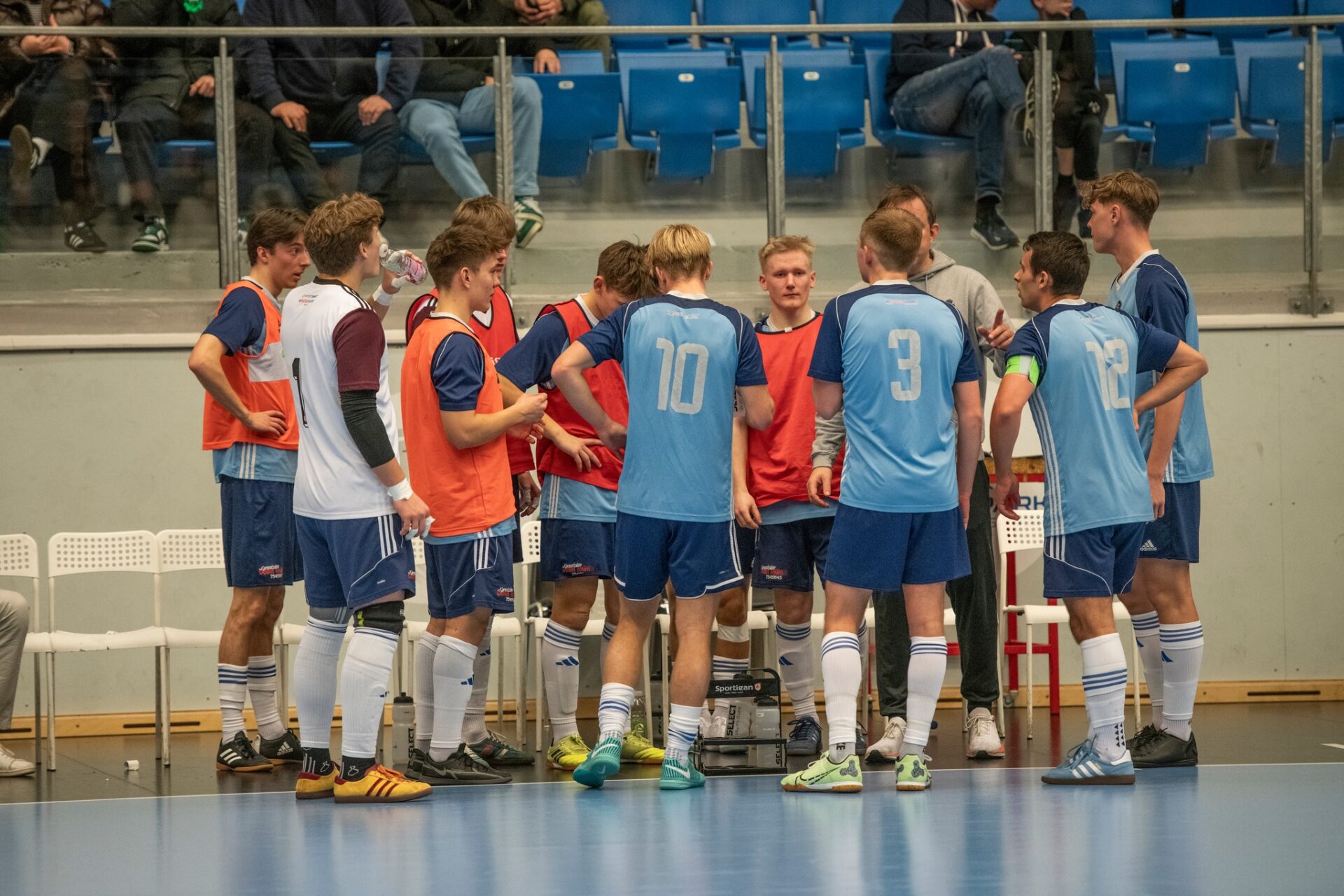 Taktikken finpudses under en timeout. Cheftræner Lars Christian Zøhner samler spillerne og justerer strategien midt i kampen.