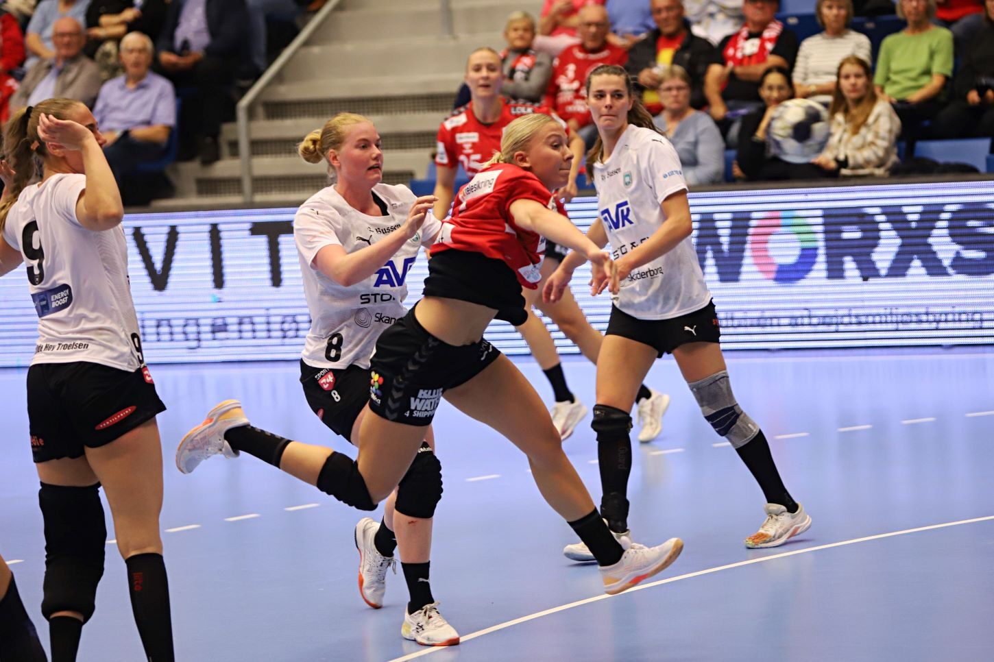 Michala Møller springer direkte mellem to forsvarsspillere. Foto: Johnny Tauman.