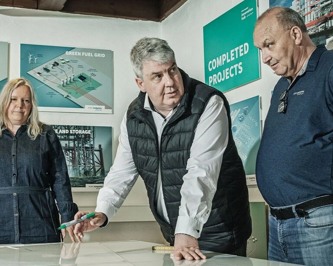 Esbjerg Havns havnedirektør, Dennis Jul Pedersen, sammen med flere kolleger i Fiskepakhuset, hvor de ser på et kort over havnens arealer. Foto: Esbjerg Havn.