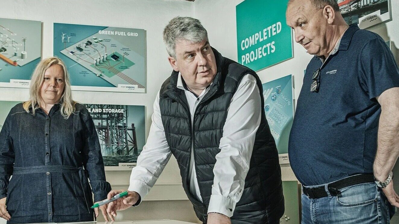 Esbjerg Havns havnedirektør, Dennis Jul Pedersen, sammen med flere kolleger i Fiskepakhuset, hvor de ser på et kort over havnens arealer. Foto: Esbjerg Havn.