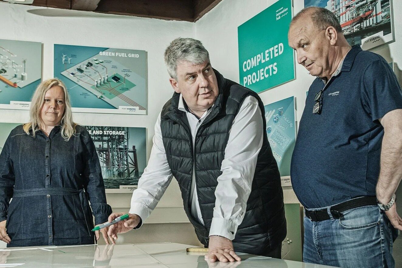Esbjerg Havns havnedirektør, Dennis Jul Pedersen, sammen med flere kolleger i Fiskepakhuset, hvor de ser på et kort over havnens arealer. Foto: Esbjerg Havn.