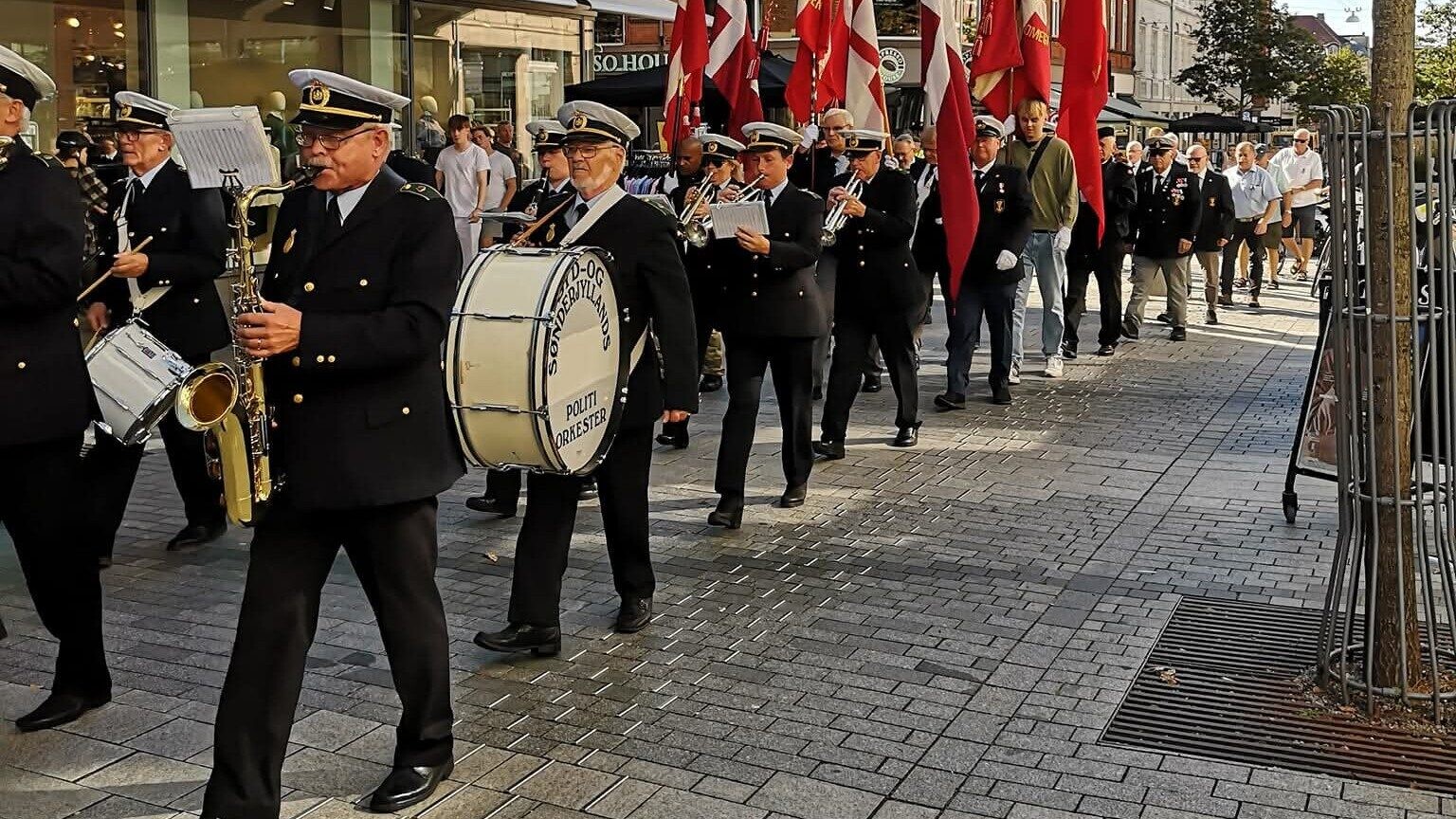 Syd- og Sønderjyllands Politiorkester på marchtur en sommerdag i gågaden. Privatfoto.