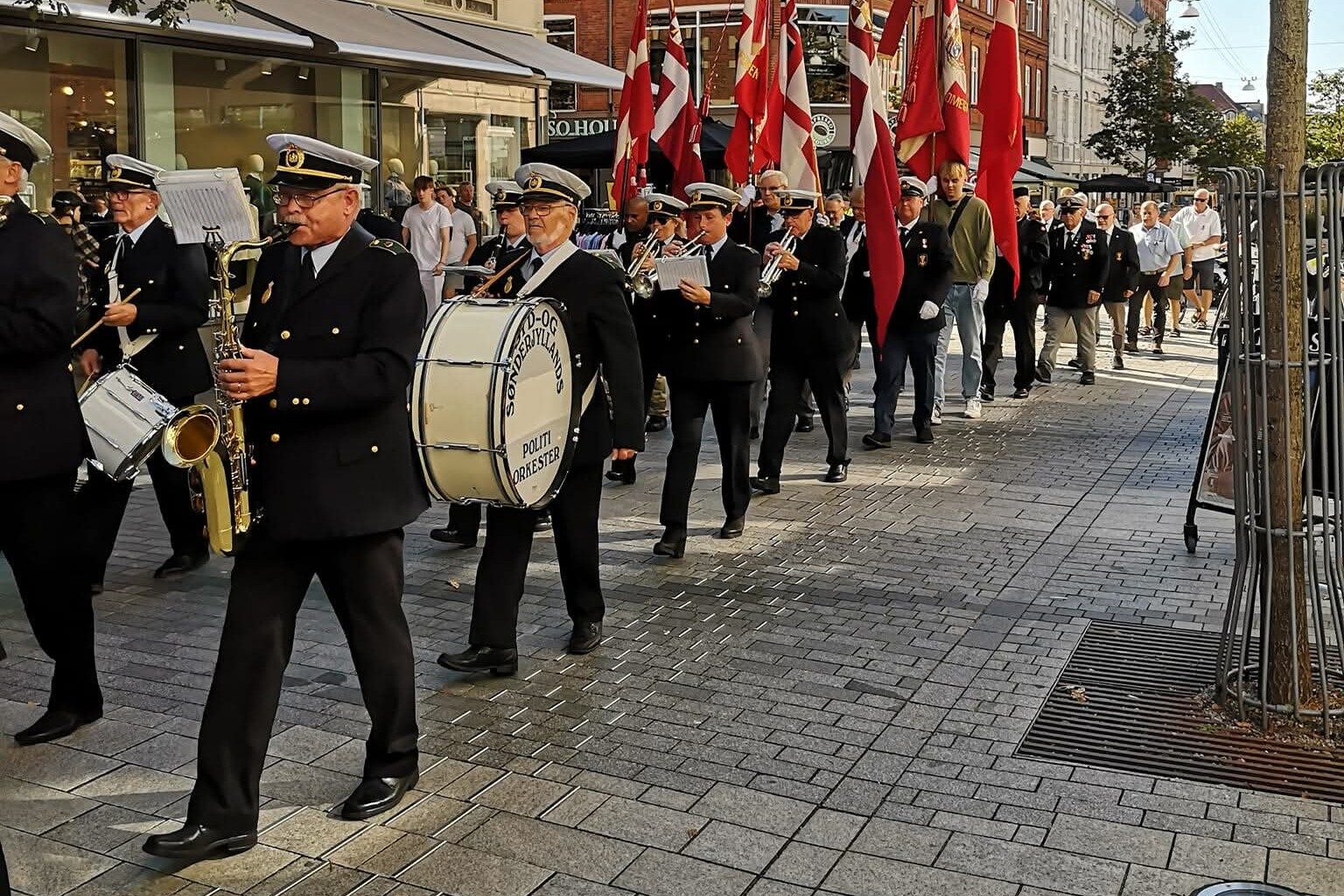 Syd- og Sønderjyllands Politiorkester på marchtur en sommerdag i gågaden. Privatfoto.