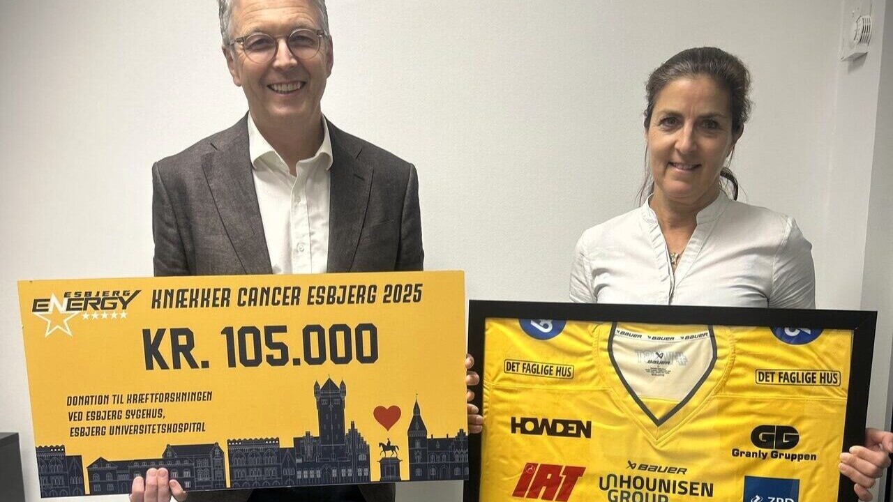 På billedet ses Frede Donskov, professor og overlæge i kræftsygdomme, og Lone Gamrath, ph.d.-studerende i kræftforskning, som modtager checken på 105.000 kroner og den signerede Knæk Cancer-trøje fra Esbjerg Energy.