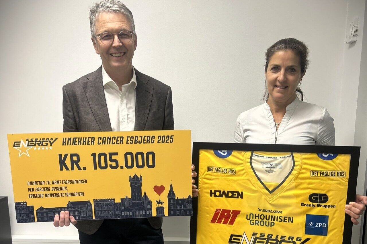 På billedet ses Frede Donskov, professor og overlæge i kræftsygdomme, og Lone Gamrath, ph.d.-studerende i kræftforskning, som modtager checken på 105.000 kroner og den signerede Knæk Cancer-trøje fra Esbjerg Energy. PR-foto.