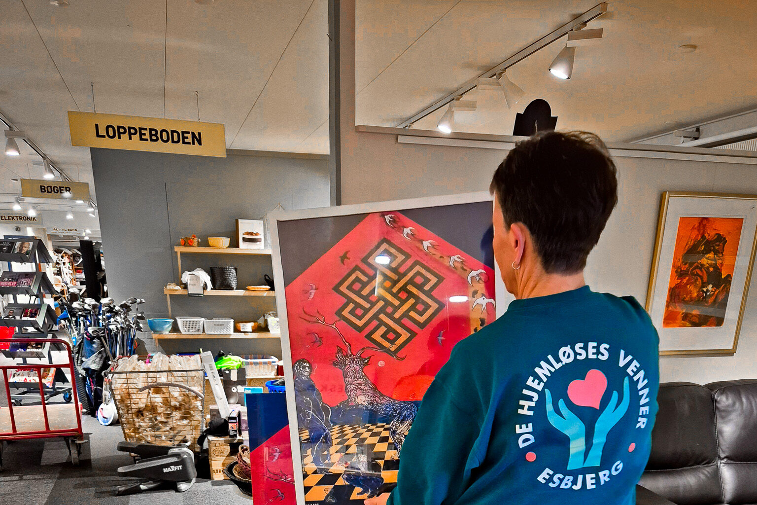 Plakaterne med Johnny Madsen-gavlen er nu en del af hverdagen hos De Hjemløses Venner, hvor salget går ubeskåret til støtte for hjemløse i Esbjerg. Foto: Camilla Uth.