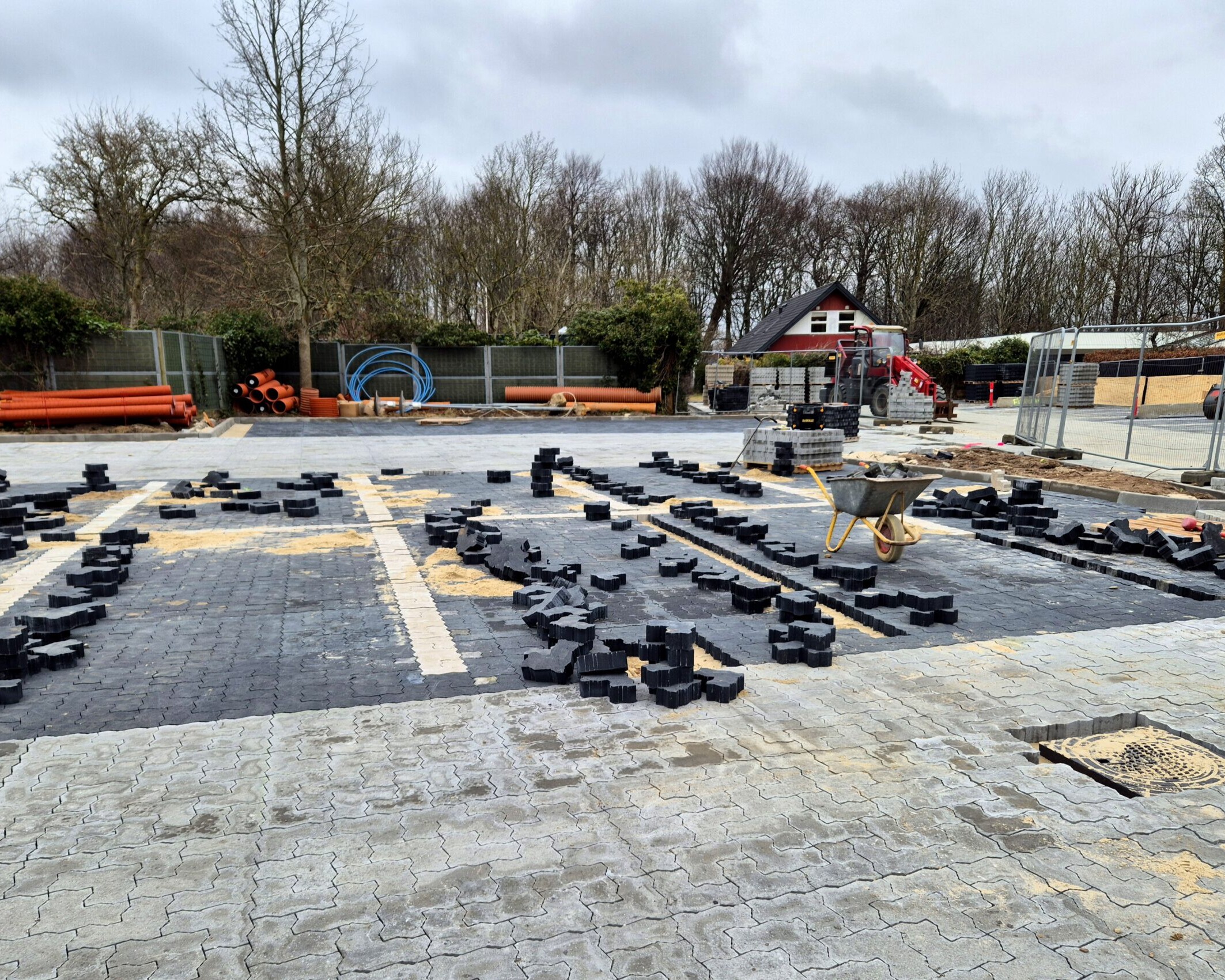 Belægningen på parkeringspladsen består af fliser i to farver, hvor de mørke markerer parkeringsbåsene. Foto: Camilla Uth.