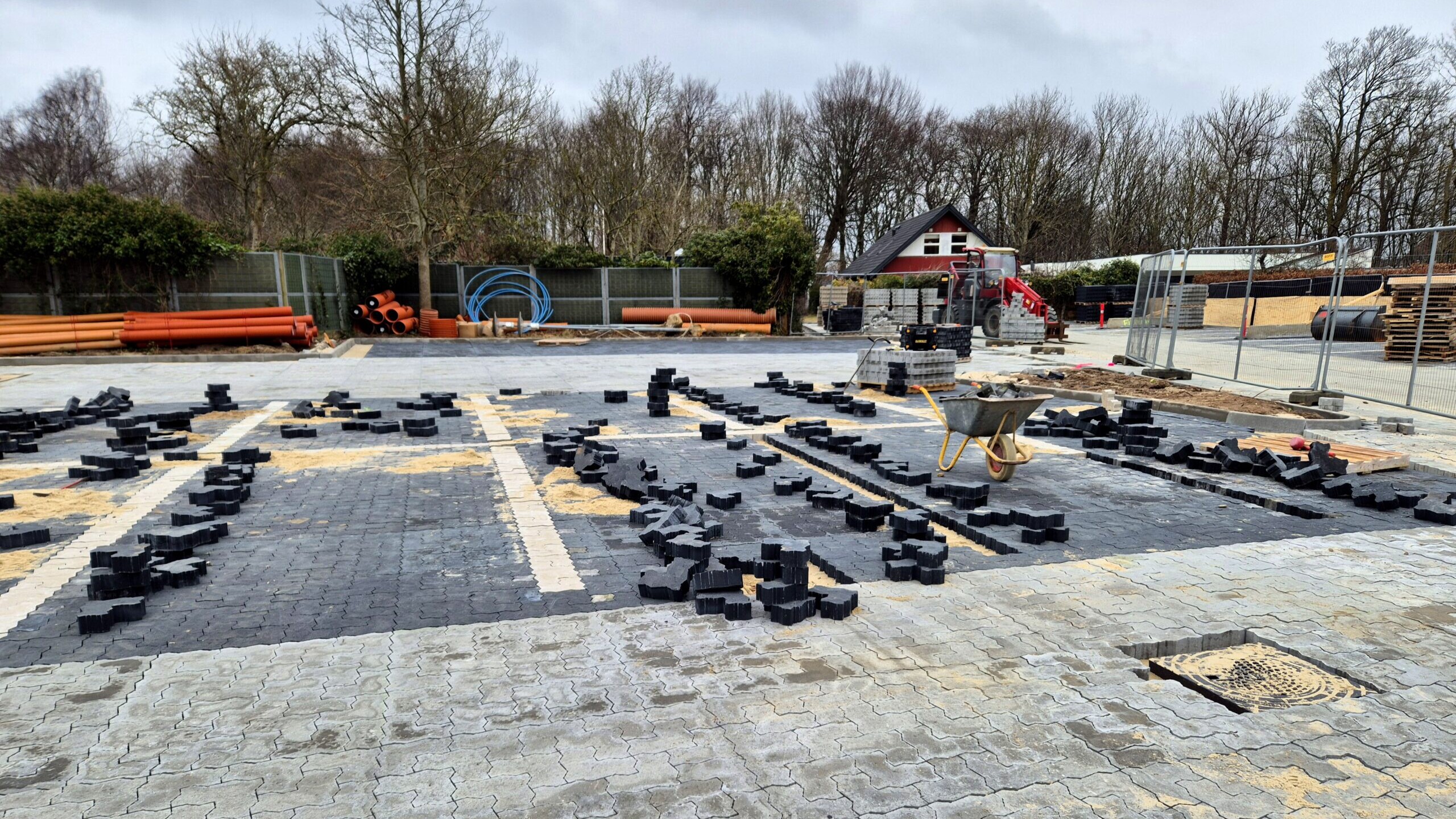 Belægningen på parkeringspladsen består af fliser i to farver, hvor de mørke markerer parkeringsbåsene. Foto: Camilla Uth.