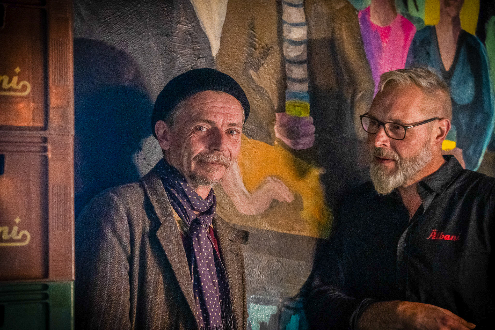 Henrik Nielsen (tv) er kunstneren bag det store vægmaleri, der hænger ved indgangen i Pub Knejpen. Foto: Fjodor Pedersen.