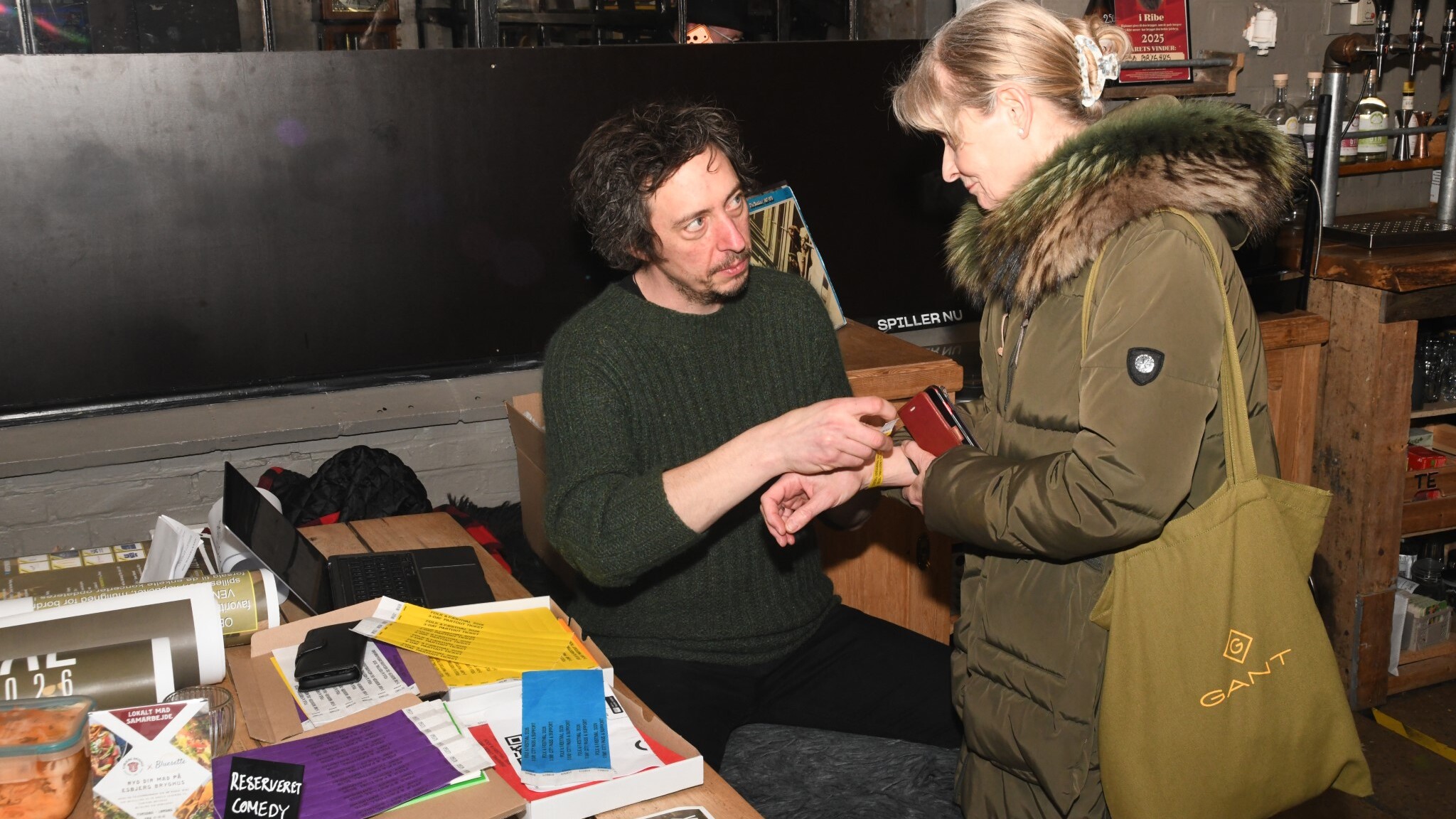 Billet bliver til armbånd. Ved bordet midt i bryghuset blev der klippet, tjekket og snakket – helt uden kø og stress. Foto: Peter Langwithz Smith.