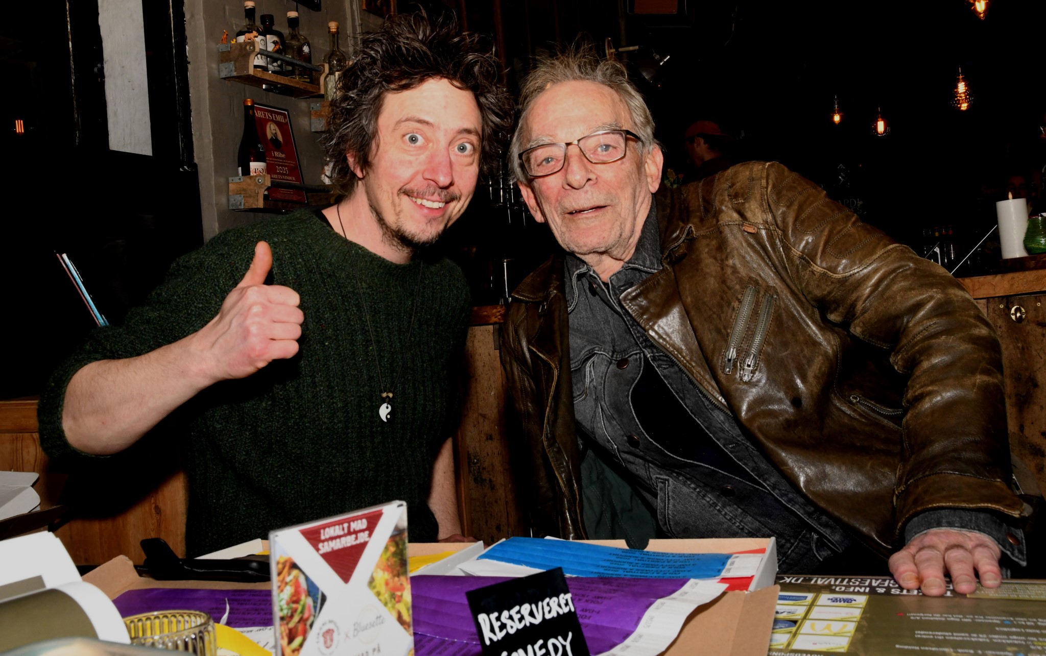 Et smil, et nik og et tommel-op fra festivalleder Casper Mikkelsen (tv). Fotograf Peter Langwithz Smith til højre. Stemningen var afslappet og imødekommende, da festivalgæsterne mødtes over armbånd, programmer og forventninger. Foto: Peter Langwithz Smith.