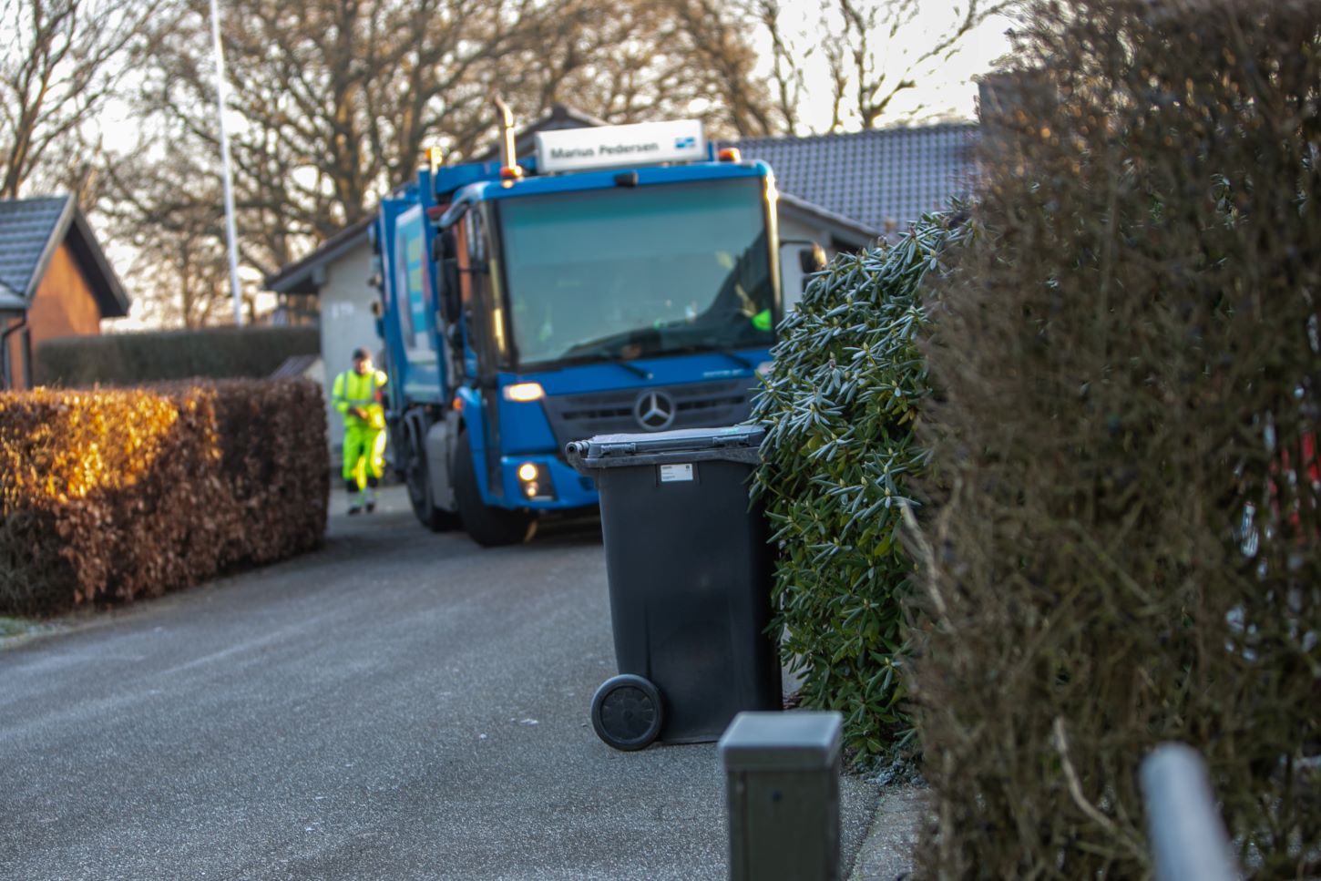 Medarbejdere i gang med tømning i et villakvarter i Fovrfeldt, hvor flere husejere har stillet affaldsspandene korrekt ved skel. Foto: Johnny Tauman.