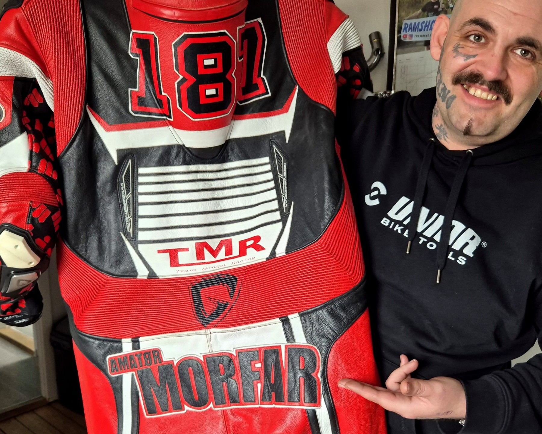 Kasper Olsen viser sin køredragt med øgenavnet “Morfar” – et navn, der har bidt sig fast i miljøet. Foto: Camilla Uth.