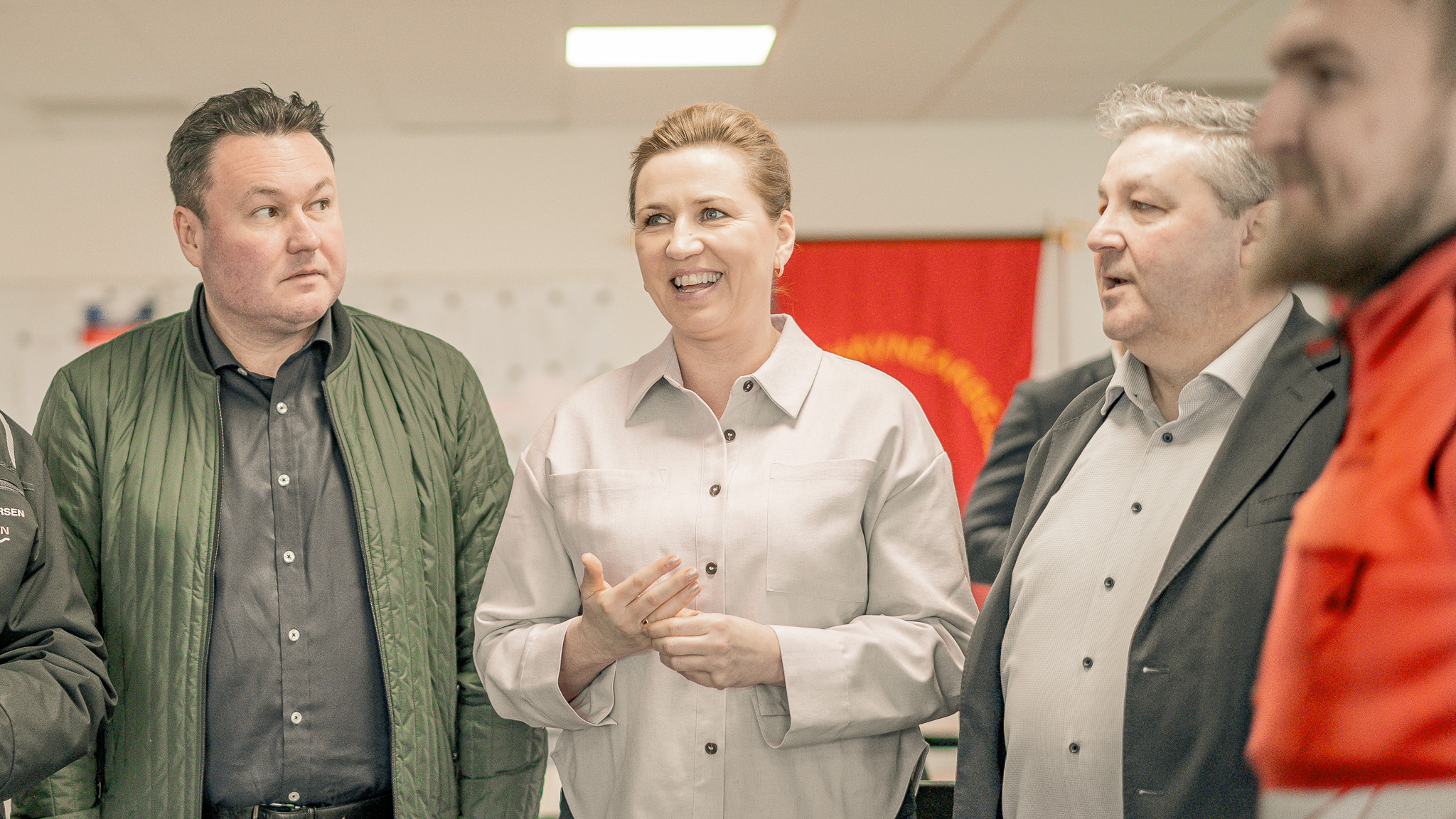Mette Frederiksen overværer mønstringen klokken 10.00. Her flankeret af Anders Kronborg (S), MF og forbundsformand i 3F, Henning Overgaard. En orange mand passerer forbi. Foto: Fjodor Pedersen.
