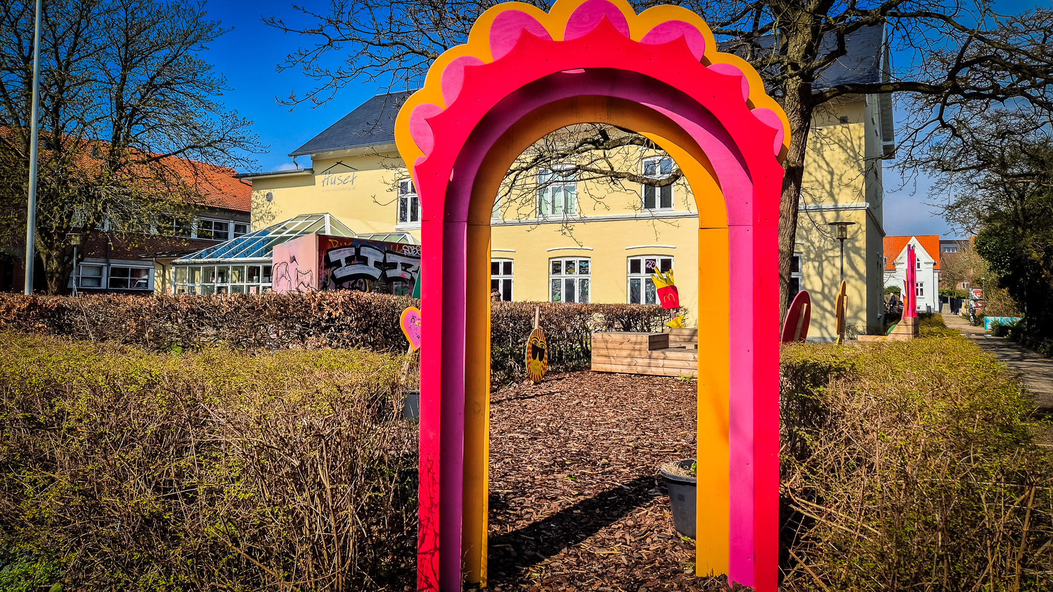 Den farverige portal markerer indgangen til den lille urbane oase ved Huset – skabt af unge til unge. Foto: Camilla Uth.