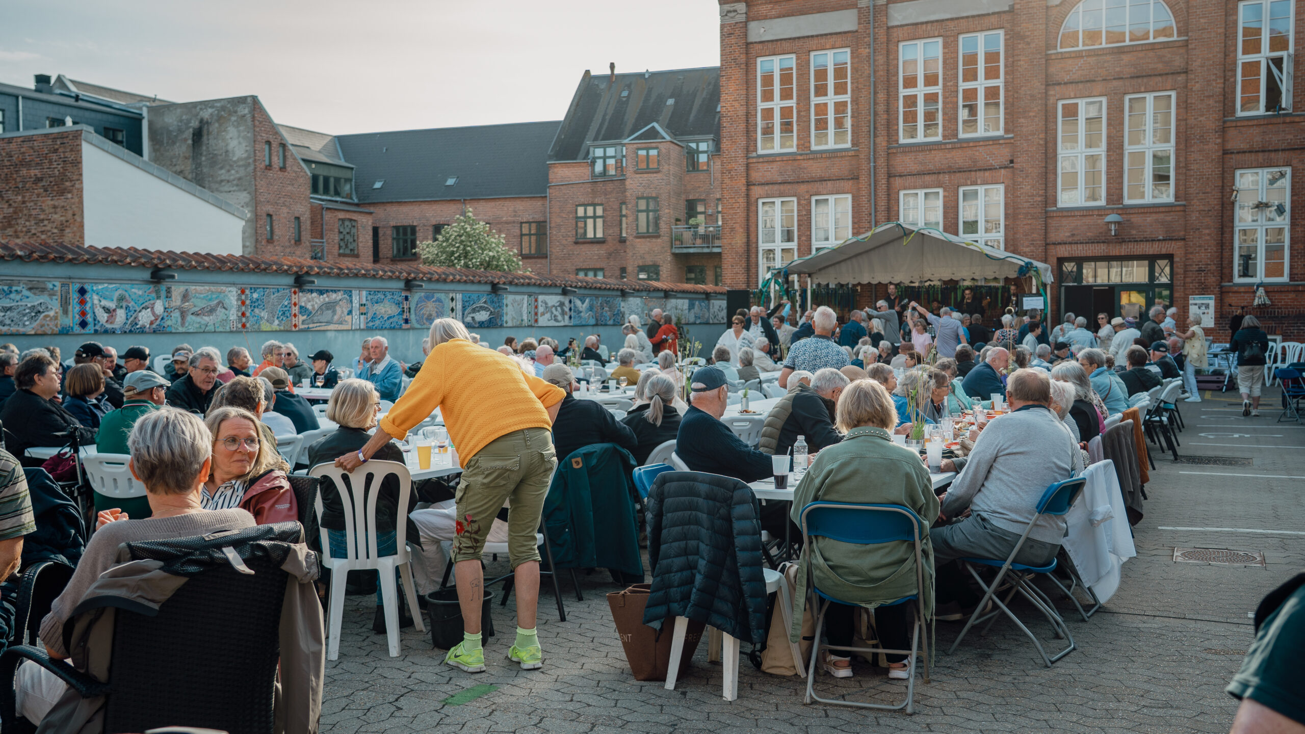 Samtaler, smil og musik gik hånd i hånd i gården bag Kultur- & Fritidshuset, hvor flere hundrede gæster lagde vejen forbi festivalen. Foto: Fjodor Pedersen.