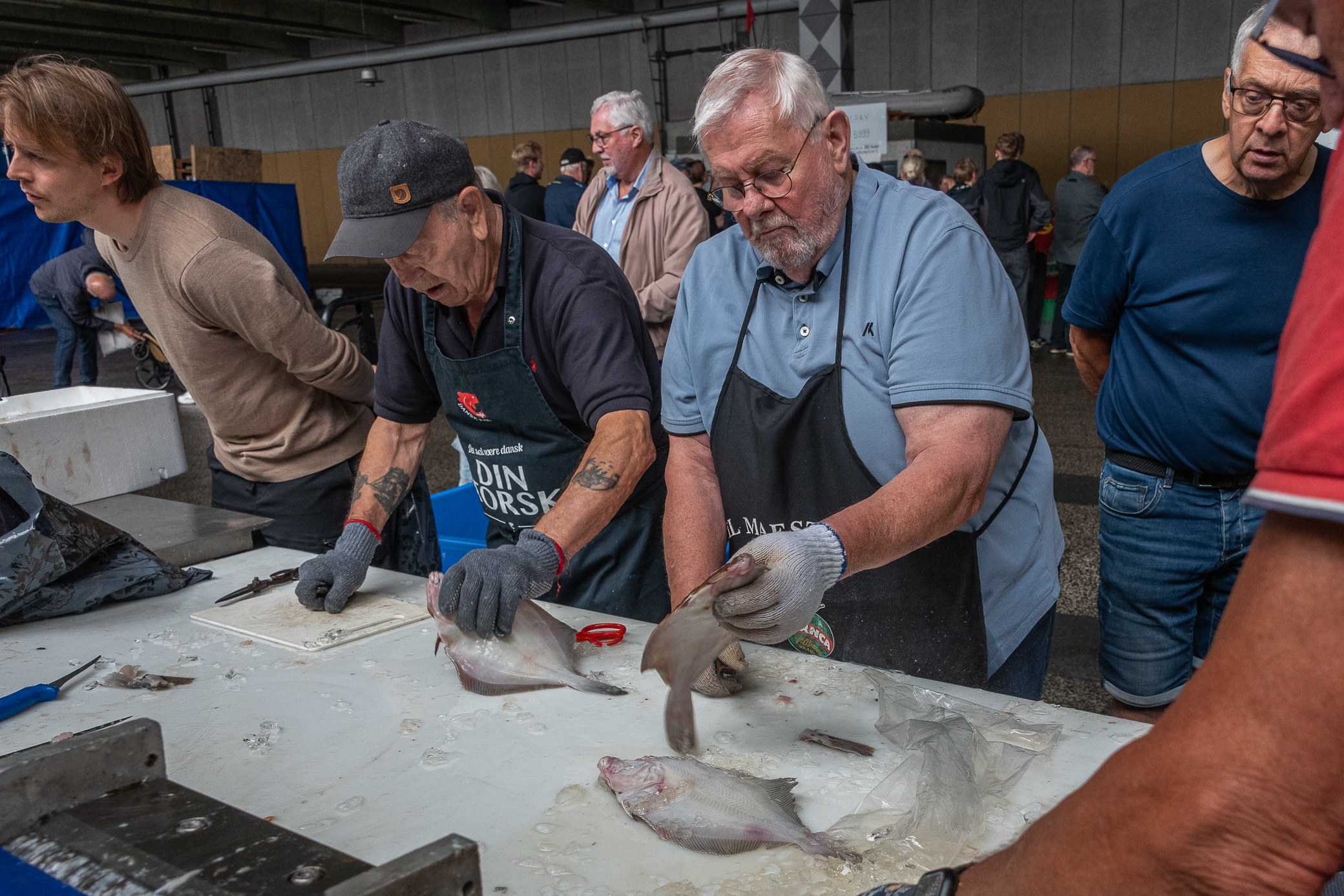 Medlemmer af Esbjergfiskernes Seniorklub står klar til at rense og klargøre dagens fangst, så køberne kan tage fiskene direkte med hjem til gryde eller pande. Foto: Claus Brinch-Danielsen.