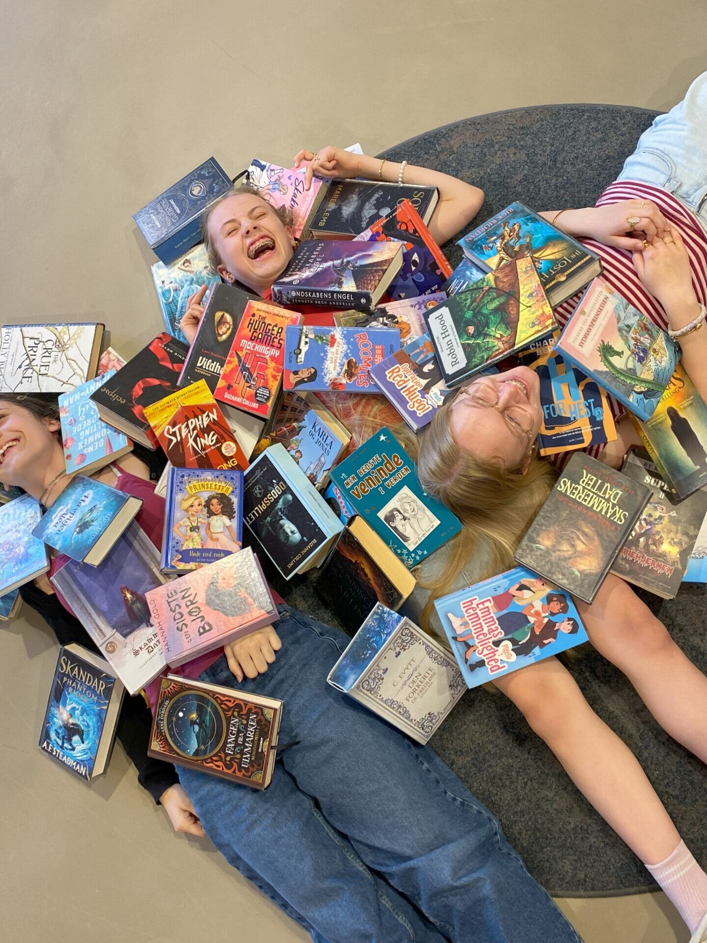 Lea, Emilie og Dea har læst sig igennem bunker af bøger og er klar til at dele deres bedste anbefalinger med andre børn, unge og forældre på Hovedbiblioteket. Pressefoto.