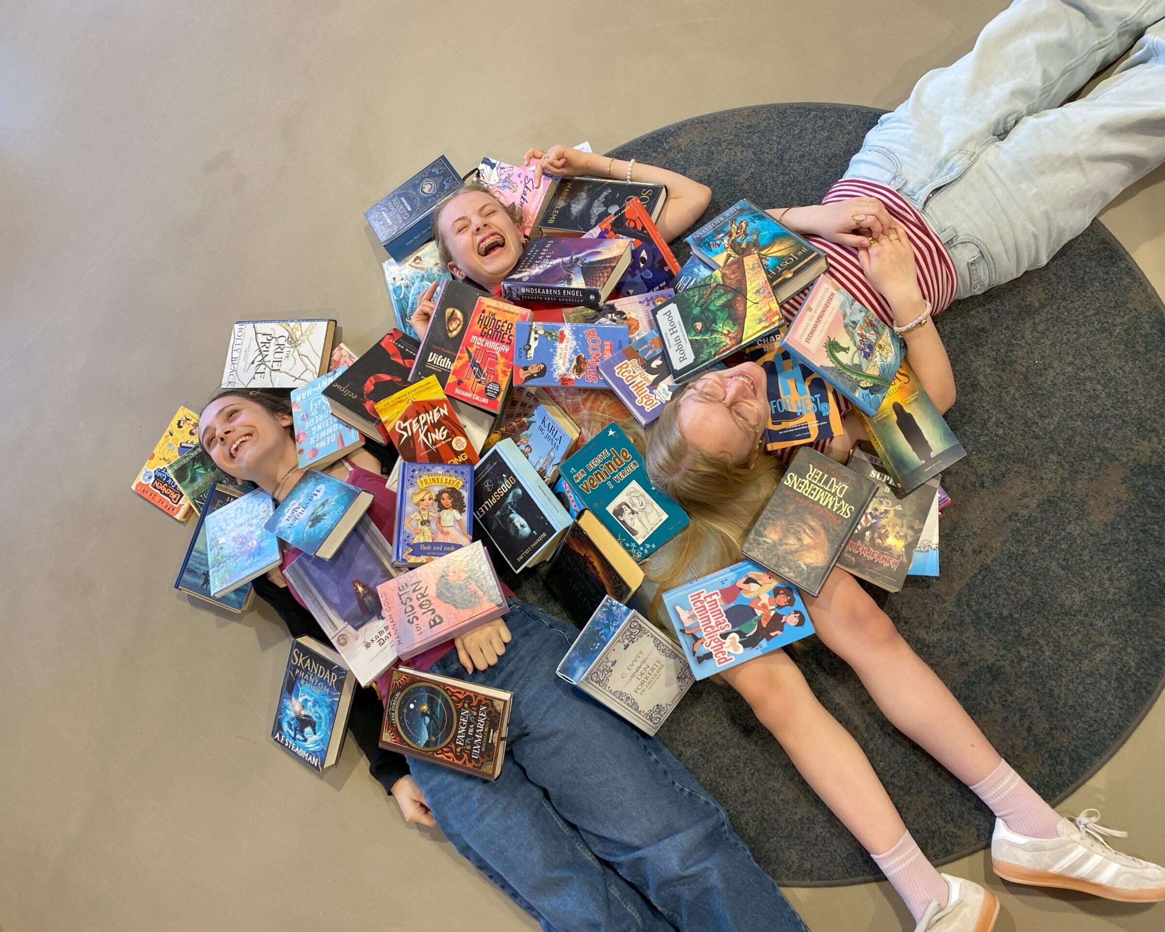 Lea, Emilie og Dea har læst sig igennem bunker af bøger og er klar til at dele deres bedste anbefalinger med andre børn, unge og forældre på Hovedbiblioteket. Pressefoto.