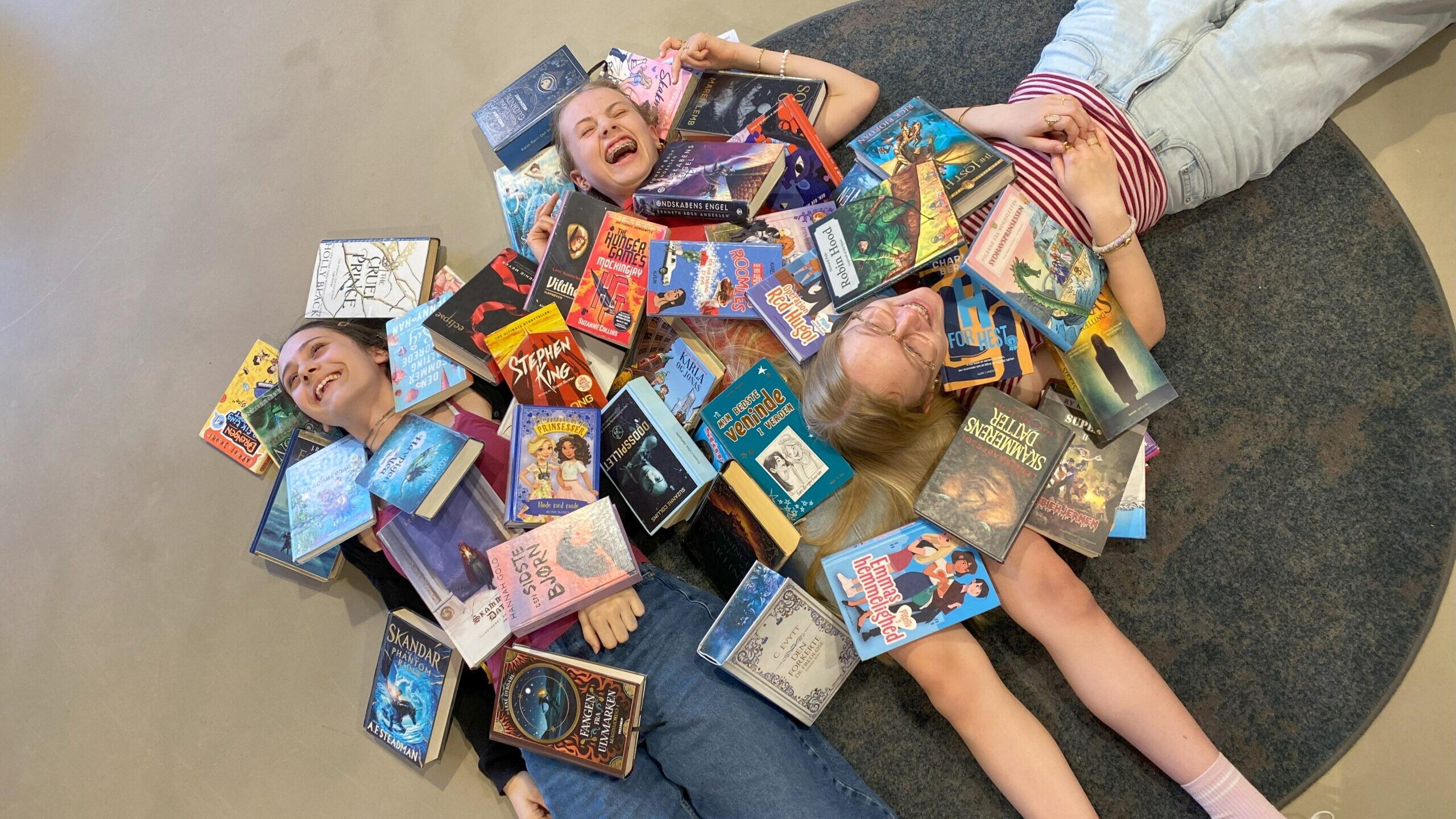 Lea, Emilie og Dea har læst sig igennem bunker af bøger og er klar til at dele deres bedste anbefalinger med andre børn, unge og forældre på Hovedbiblioteket. Pressefoto.