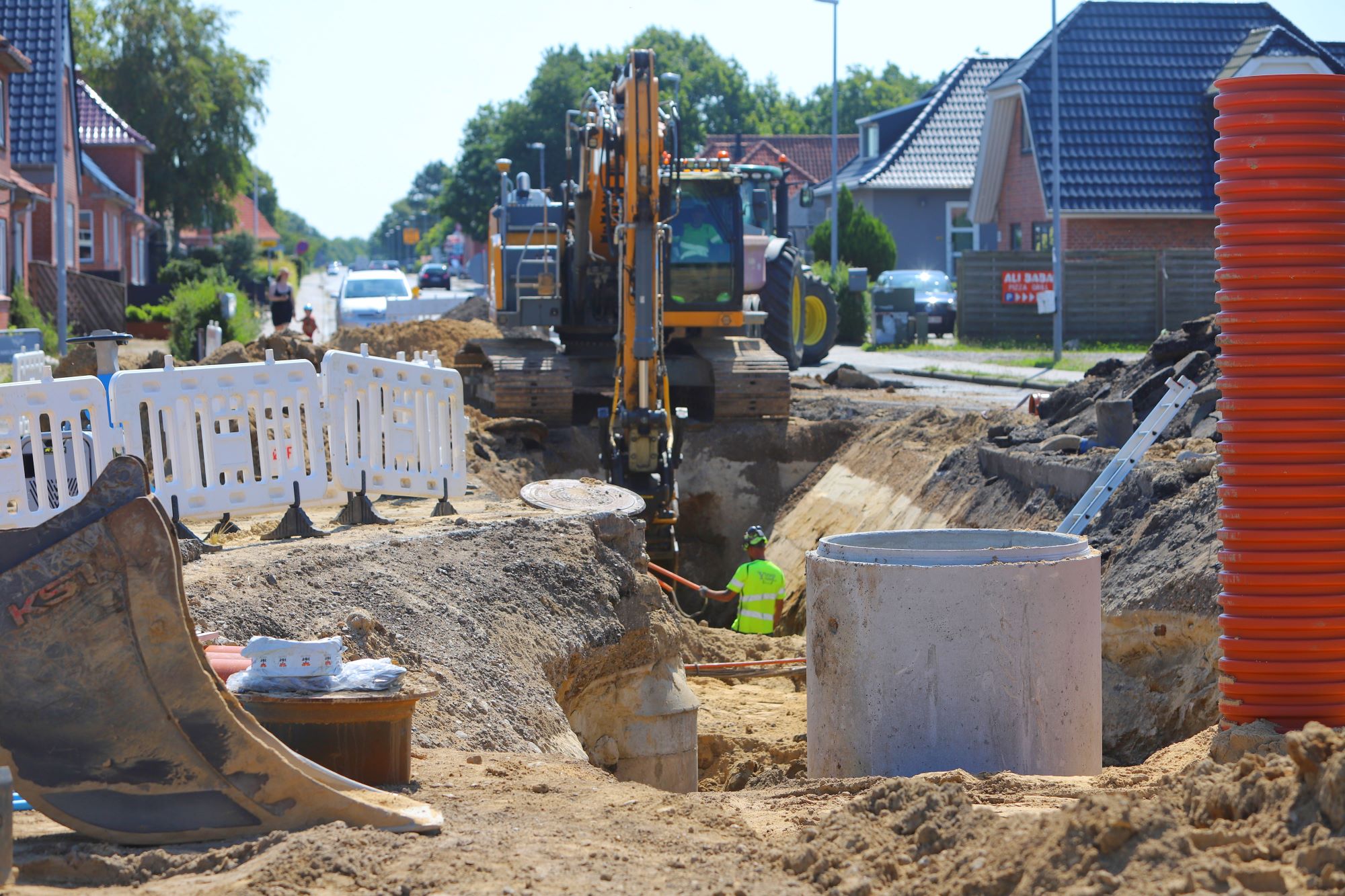 En medarbejder fra Ytrup Anlæg fordeler sand i udgravningen, mens gravearbejdet fortsætter i rundkørslen. Foto: Johnny Tauman.
