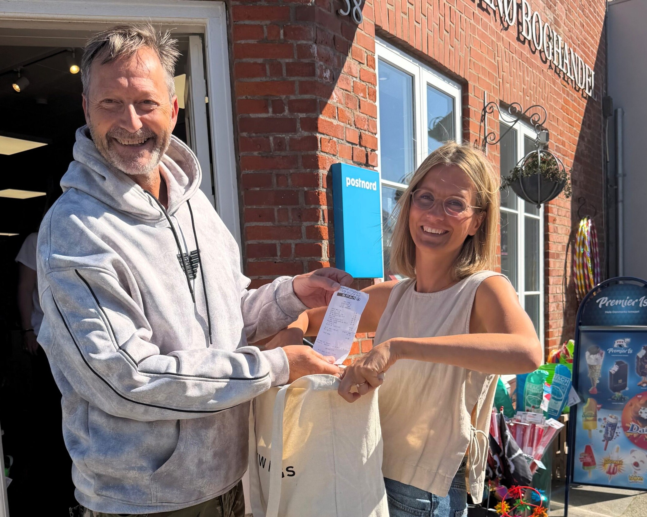 Nordby Handelsstandsforening overrækker et af de mange gavekort til en af de heldige vindere. Konkurrencen vender tilbage med en ny lodtrækning i oktober. PR-foto.