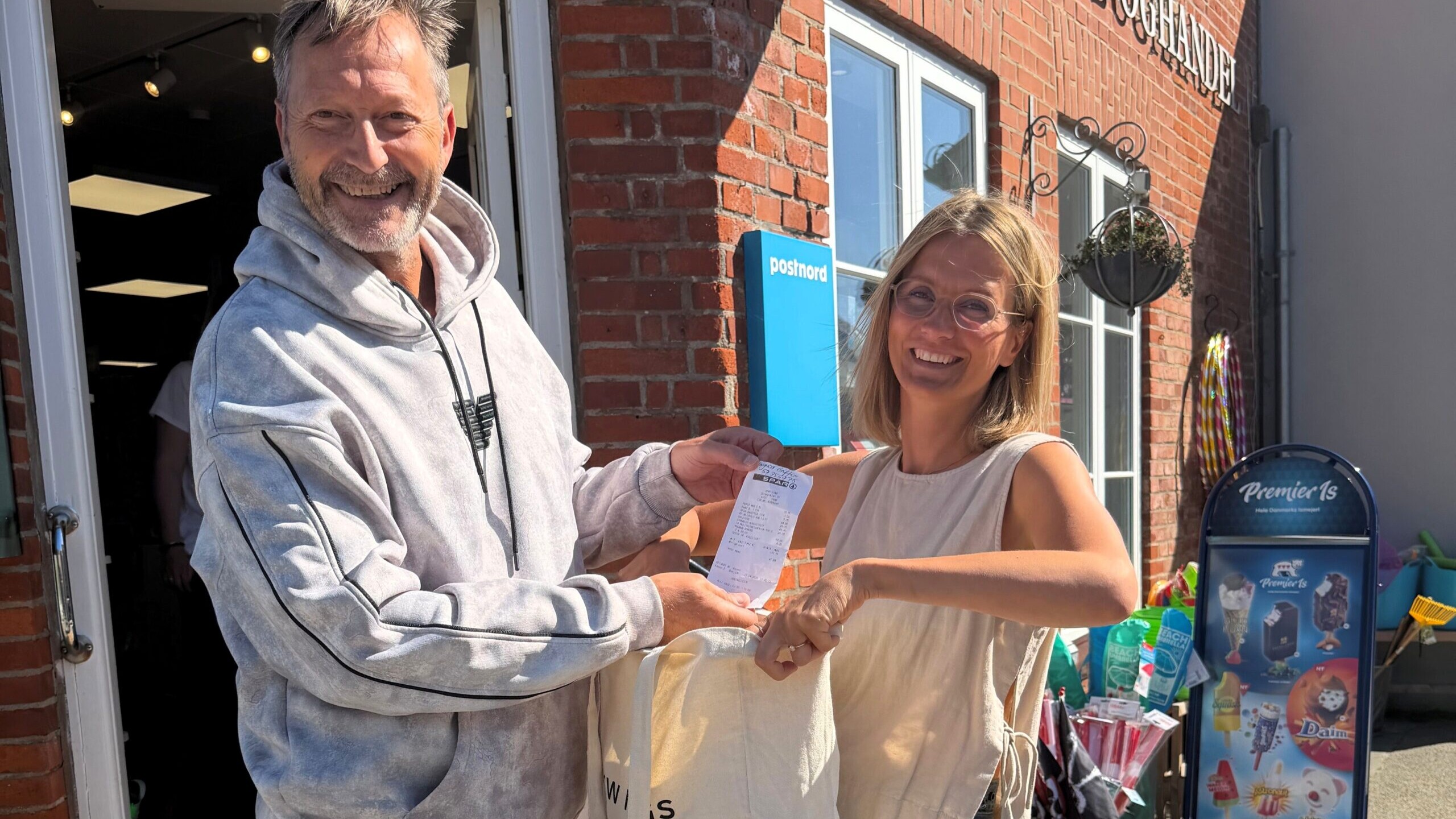 Nordby Handelsstandsforening overrækker et af de mange gavekort til en af de heldige vindere. Konkurrencen vender tilbage med en ny lodtrækning i oktober. PR-foto.